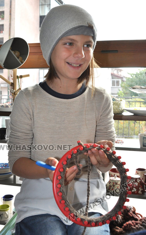9-годишната Дивна вече е много сръчна в плетенето на шапки на станче