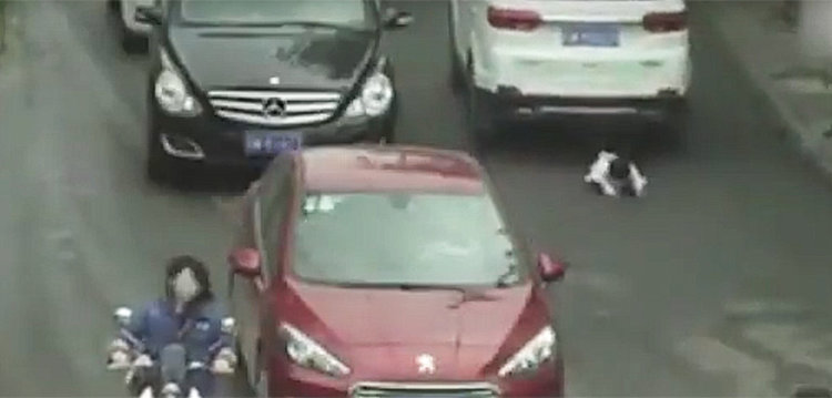 Двегодишна на улицата, две коли минават над нея (видео)