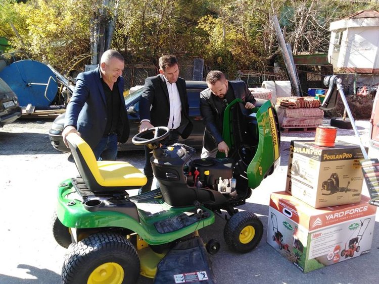 Николай показва на кмета и служителите новата техника за косене