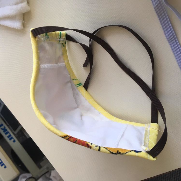 Маската е изработена от три пласта от 100% памук, с джобче от вътрешната страна, в което могат да се слагат напръскани с дезинфектант допълнителни кърпички и да се сменят.