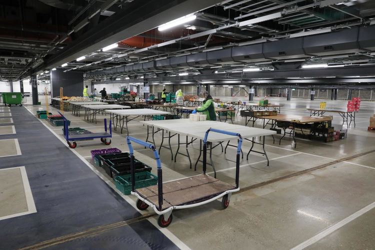 Доброволци приготвят храна и храна на разпределителен център на подземния паркинг на стадион "Тотнъм Хотспър" в Лондон