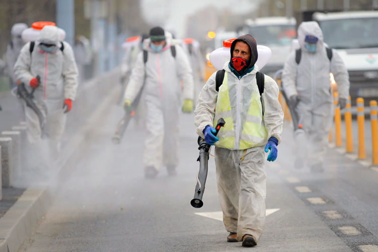 Общински служители със защитни костюми дезинфекцират район на Букурещ, във вторник, 31 март 2020 г., където властите се опитват да ограничат разпространението на коронавируса