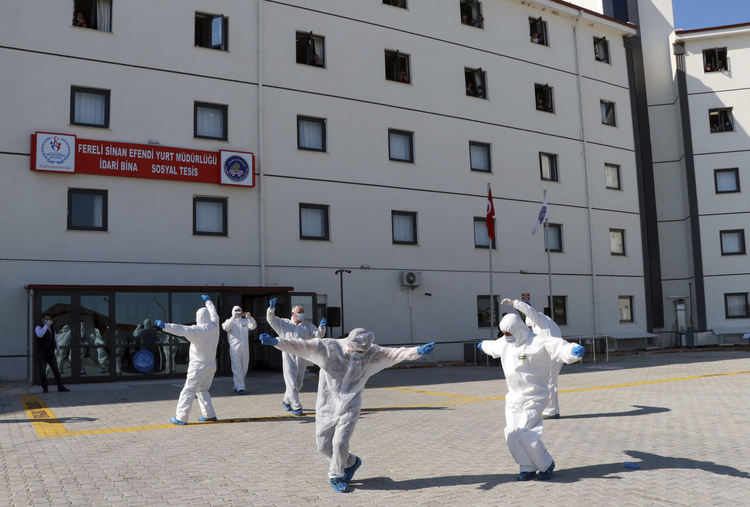 Здравни служители в защитни облекла танцуват на импровизирана церемония за изпращането на хора, прекарали двуседмична задължителна карантина в общежитието на университета, в Бурдур, югозападна Турция, в понеделник, 13 април 2020 г. Сто петдесет и един турски граждани, завърнали се от Русия, Казахстан и Узбекистан, бяха изпратени до домовете си в 32 различни града, след като бяха поставени под карантина на 29 март. Шест души, които са положителни с Covid -19 се лекуват в местната болница