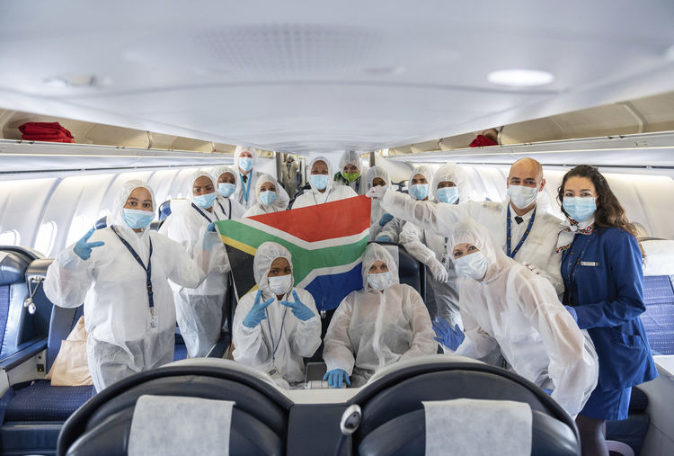 Екипажът на Airbus A340-600 на авиокомпания South African Airlines позира след кацане от Кейптаун в защитните си дрехи срещу коронавирусна инфекция за снимка във Франкфурт, Германия, петък, 24 април 2020 г. Това беше последният обратен полет засега