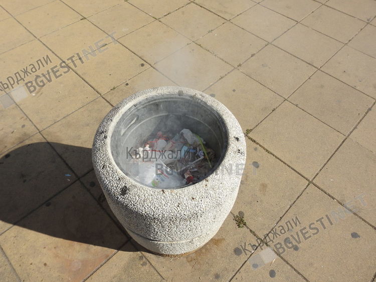 Родител дава пример на детето си-подминава безучастно подпалено кошче за боклук в центъра