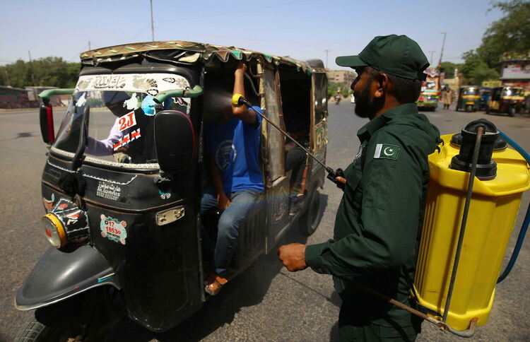 Доброволци пръскат хладна вода върху хора по улица, докато горещата вълна продължава в Карачи, Пакистан, 15 май 2022 г.  EPA/SHAHZAIB AKBER