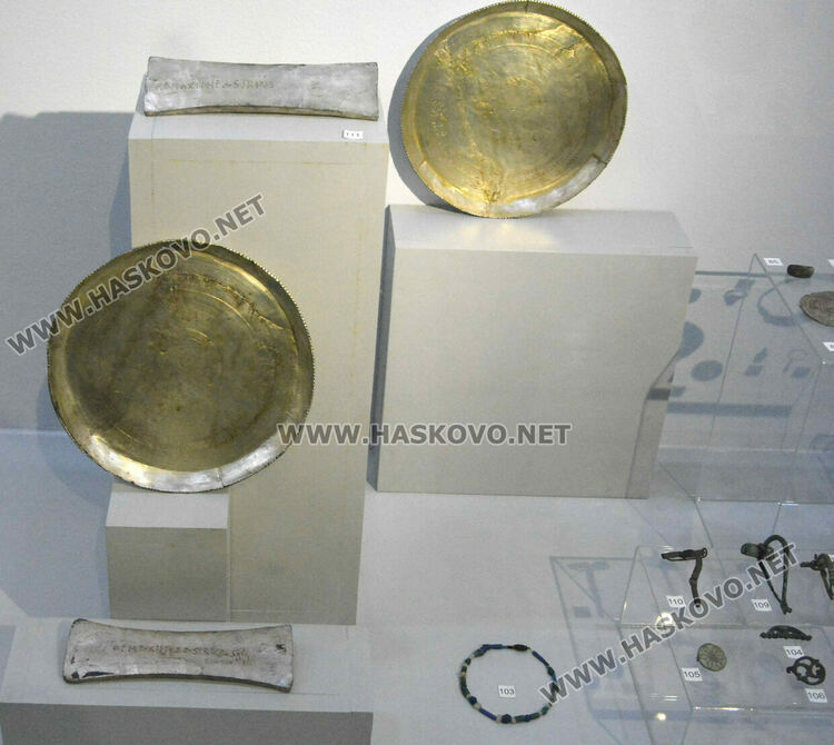 Сребърните посуда от съкровището на Лициний, служили години наред за хранилка на кокошки в с. Сираково. Под тях са  изложени лабриси