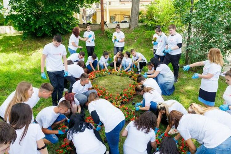 Цветна леха под формата на червена панделка засадиха ученици от Радомир
