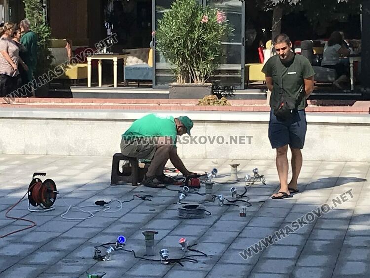 Работници тестват цветното осветление на фонтана