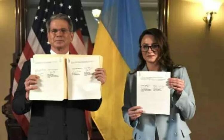 Министърът на финансите Скот Бесънт и вицепремиерът и министър на икономиката Юлия Свириденко показват подписаното рамково споразумение