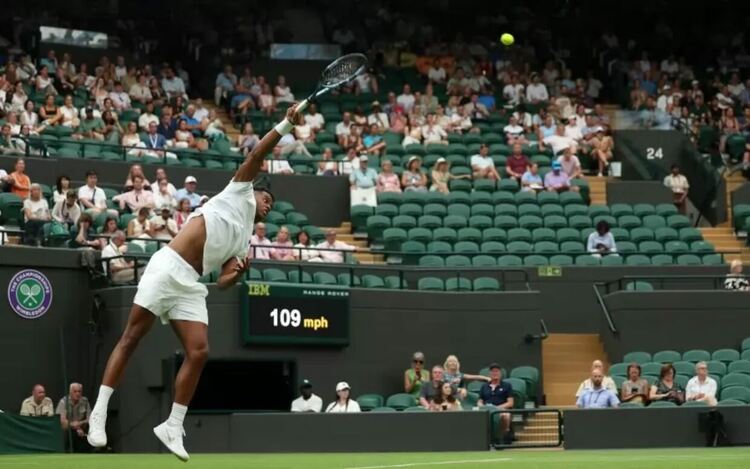 Джовани Мпечи Перикар изпълнява поредния бомбен сервис към полето на Тейлър Фриц в мача от I кръг на „Уимбълдън“.