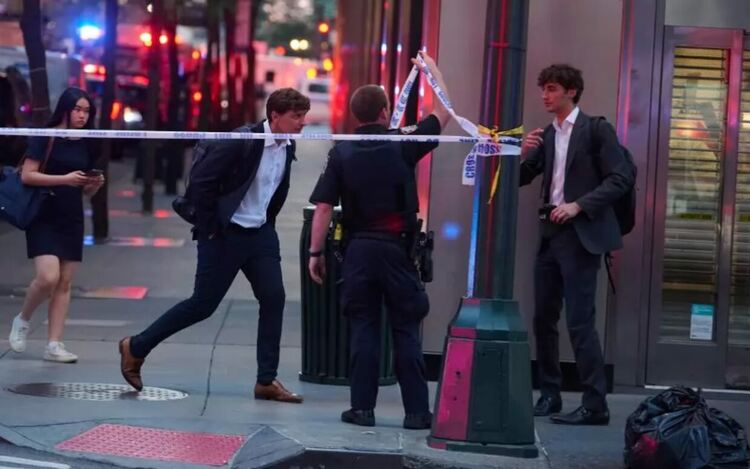 Пешеходец преминава през огражденията, докато служители на полицията на Ню Йорк реагират на инцидент с активен стрелец в Мидтаун, случил се в сградата на 345 Парк Авеню. Полицията потвърди, че стрелецът е бил „неутрализиран“ .