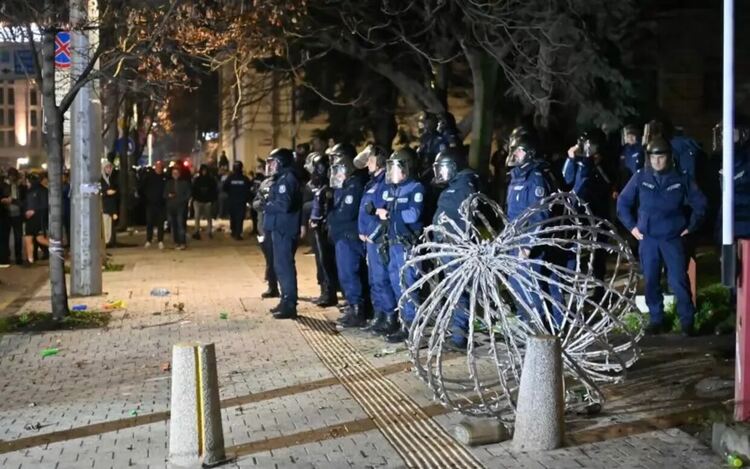 Полицаи, които „героично“ не противоречат на вандалите.