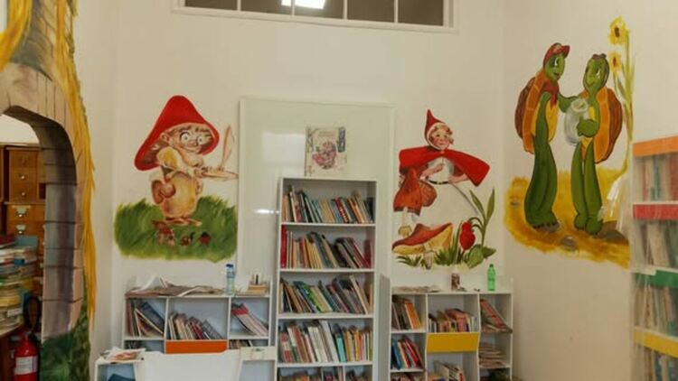 Младата художничка Ивайла Василева рисува приказни герои в детския отдел на Регионалната библиотека