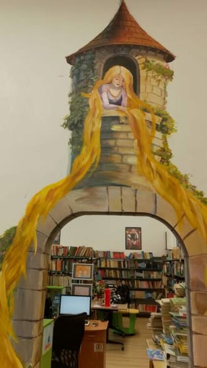 Младата художничка Ивайла Василева рисува приказни герои в детския отдел на Регионалната библиотека