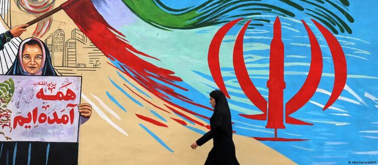 Жена преминава край знаме с антиамерикански и антиизраелски лозунги