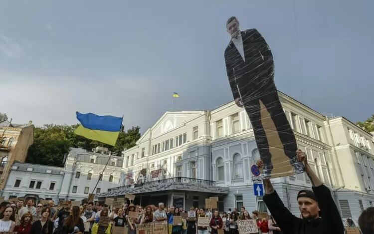 Украинец носи плакат с образа на Михайло Федоров в центъра на Киев по време на протестите срещу неговото уволнение в края на юли.